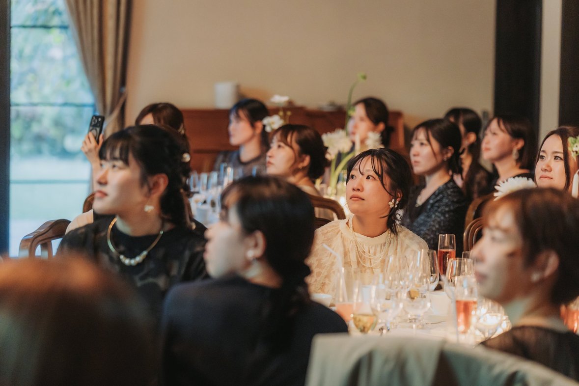 結婚式でサプライズムービーを見つめるゲスト